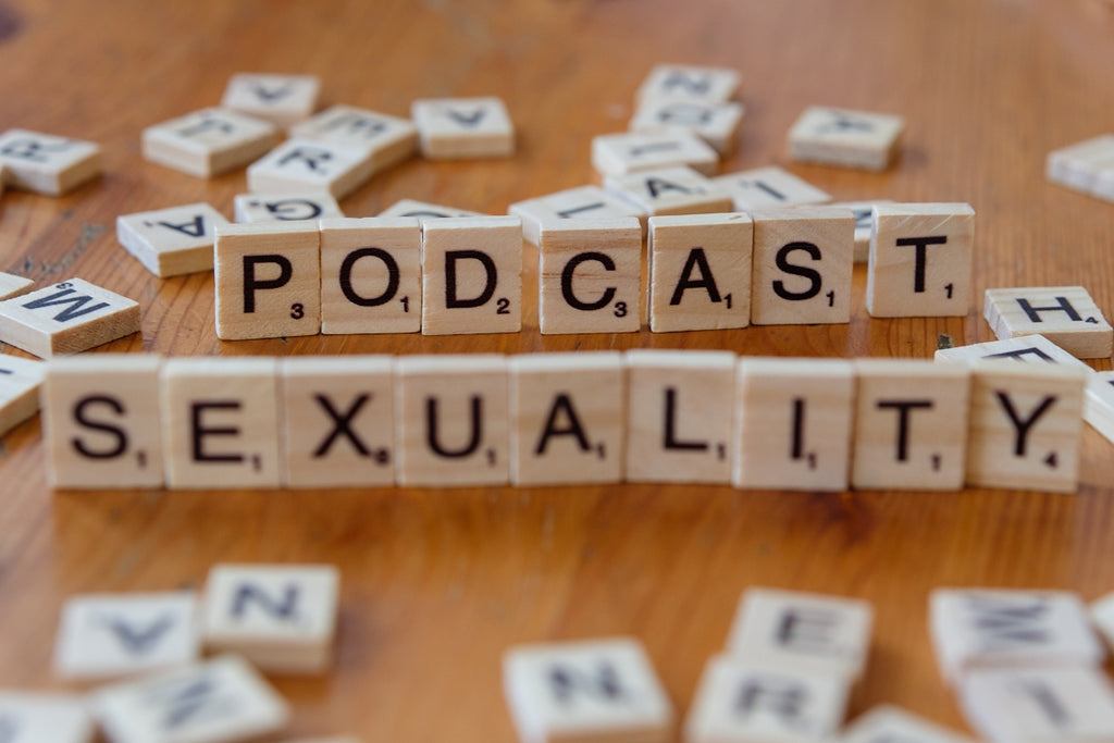 A wooden table topped with scrabble tiles that spell out the word sex and